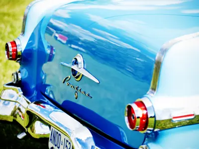 The back end of a blue vintage Pontiac