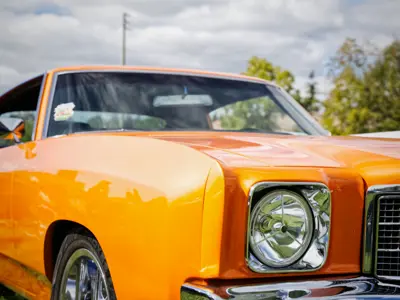 The front of a yellow vintage car from Applefest 2022