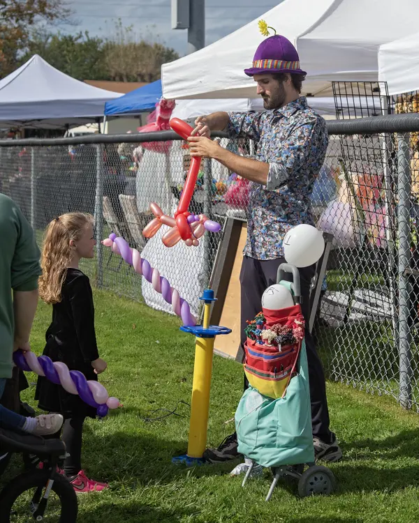 Girl waiting for a balloon to be blown up.
