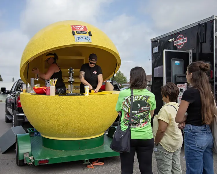 Food vendor booth shaped like a lemon serves lemonade.