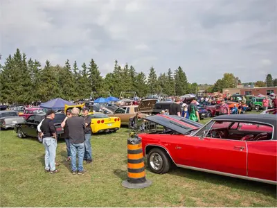 Hundreds of cars parked with people walking for the Car Show.